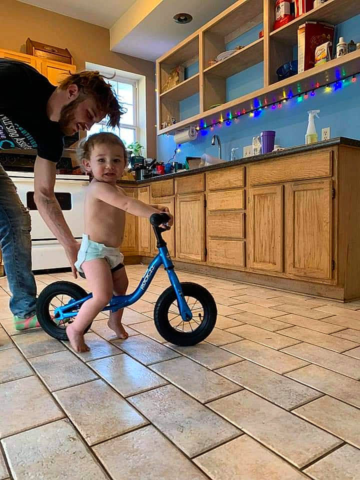Roland is registered to the contest to win money with this photo: arm, auto_part, automotive_wheel_system, baby, bicycle, cabinetry, countertop, cupboard, drawer, home, kitchen, leg, light_fixture, person, rolling, shelf, spoke, tire, toddler, wheel