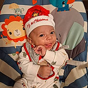 Zaire joined the competition — help win amazing prizes! baby, child, infant, smiling, christmas, santa_hat, festive, portrait, indoor, baby_bouncer, animal_pattern, elephant, lion, mouse, colorful, seated, onesie, happy, holiday, close_up
