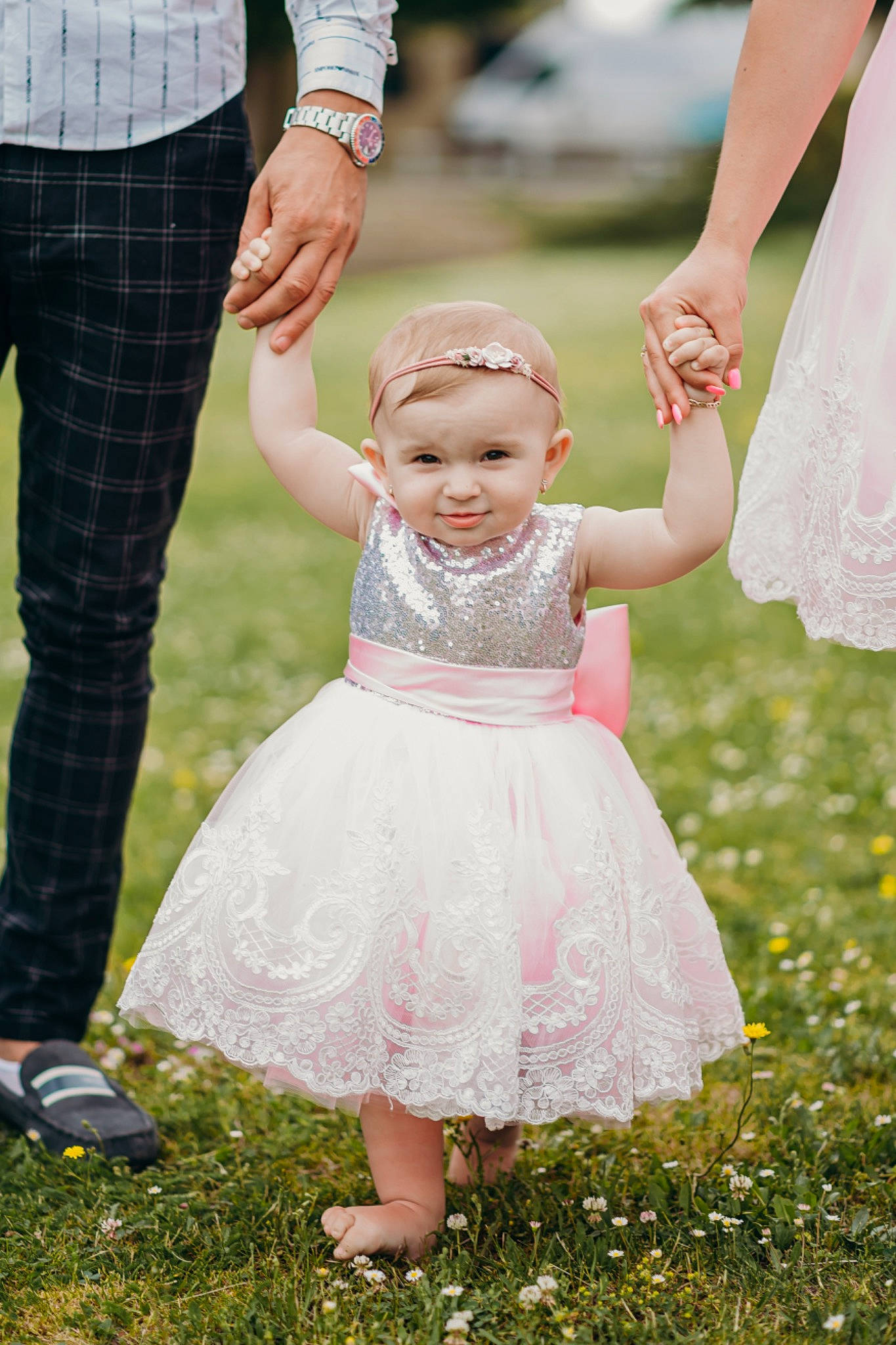 Amelia is registered to the contest to win money with this photo: baby_toddler_clothing, bridal_clothing, clothing, finger, gesture, grass, hand, happy, headwear, holding_hands, human, interaction, joy, people_in_nature, person, photograph, pink, plant, shoe, standing