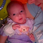 Pheonix is registered to the contest to win money with this photo: baby, woman, blanket, face, closeup, heart_shaped_lights, purple, blue, pattern, clothing, infant, holding, bed, soft_lighting, intimate, mother_and_child, cute, warm, indoor, portrait