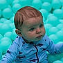 baby, infant, child, ball_pit, teal_balls, swimsuit, shark_print, face, eyes, curious_expression, sitting, play, soft_toys, portrait, cute, skin, hair, hand, indoors, closeup