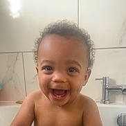 Kayden joined the competition — help win amazing prizes! toddler, child, bathroom, bathtub, water, curly_hair, smiling, happy, naked, faucet, tiles, skin, face, teeth, playful, young_child, indoor, water_flow, person, joy