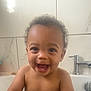 toddler, child, bathroom, bathtub, water, curly_hair, smiling, happy, naked, faucet, tiles, skin, face, teeth, playful, young_child, indoor, water_flow, person, joy