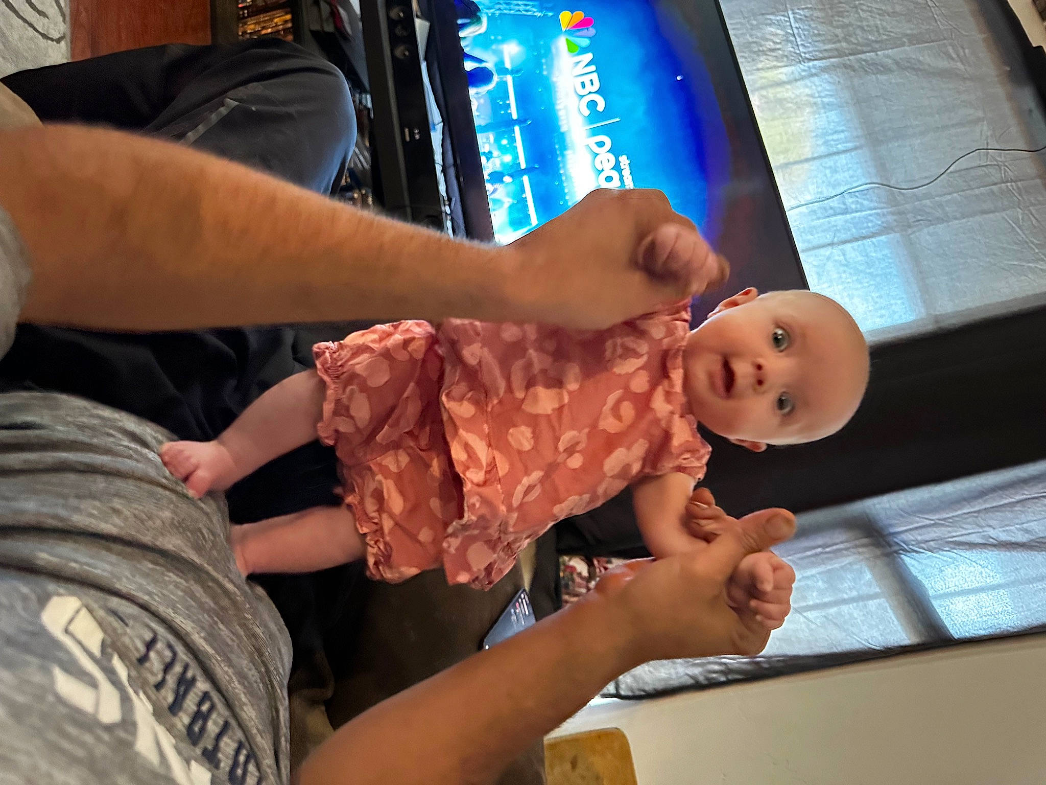 Nayvi is registered to the contest to win money with this photo: arm, baby, child, comfort, display_device, elbow, finger, fun, gesture, hand, human, human_leg, joint, military_camouflage, nail, person, t_shirt, thigh, thumb, toddler