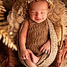 newborn, baby, smiling, flower_crown, knitted_blanket, basket, soft_texture, sleeping, cute, infant, wrapped, cozy, warm_light, portrait, peaceful, child, hands, feet, indoor, closeup