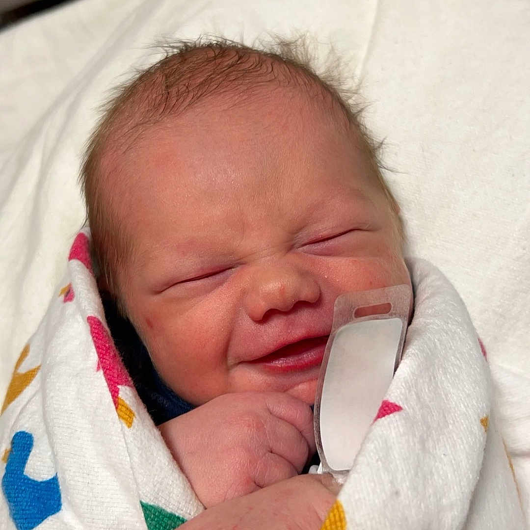 Brett is registered to the contest to win money with this photo: architecture, baby, bed, blanket, building, clothing, cushion, face, furniture, glove, head, homedecor, hospital, newborn, person, photography, portrait, quilt, sleeping, towel