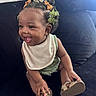 baby, bib, child, clothing, couch, cute, footwear, hair_bows, hand, happy, indoors, infant, person, playful, portrait, shoes, sitting, skin, smiling, young