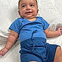 Ibrahim joined the competition — help win amazing prizes! baby, child, smiling, blue_clothing, shorts, onesie, lying_down, white_background, cute, happy, infant, skin, face, arms, legs, indoors, portrait, young, person, toddler