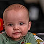 Jasper joined the competition — help win amazing prizes! baby, child, face, smile, infant, green_clothing, toy, indoor, portrait, cute, young_child, seated, colorful, background_blur, person, head, eyes, cheeks, expression, baby_seat