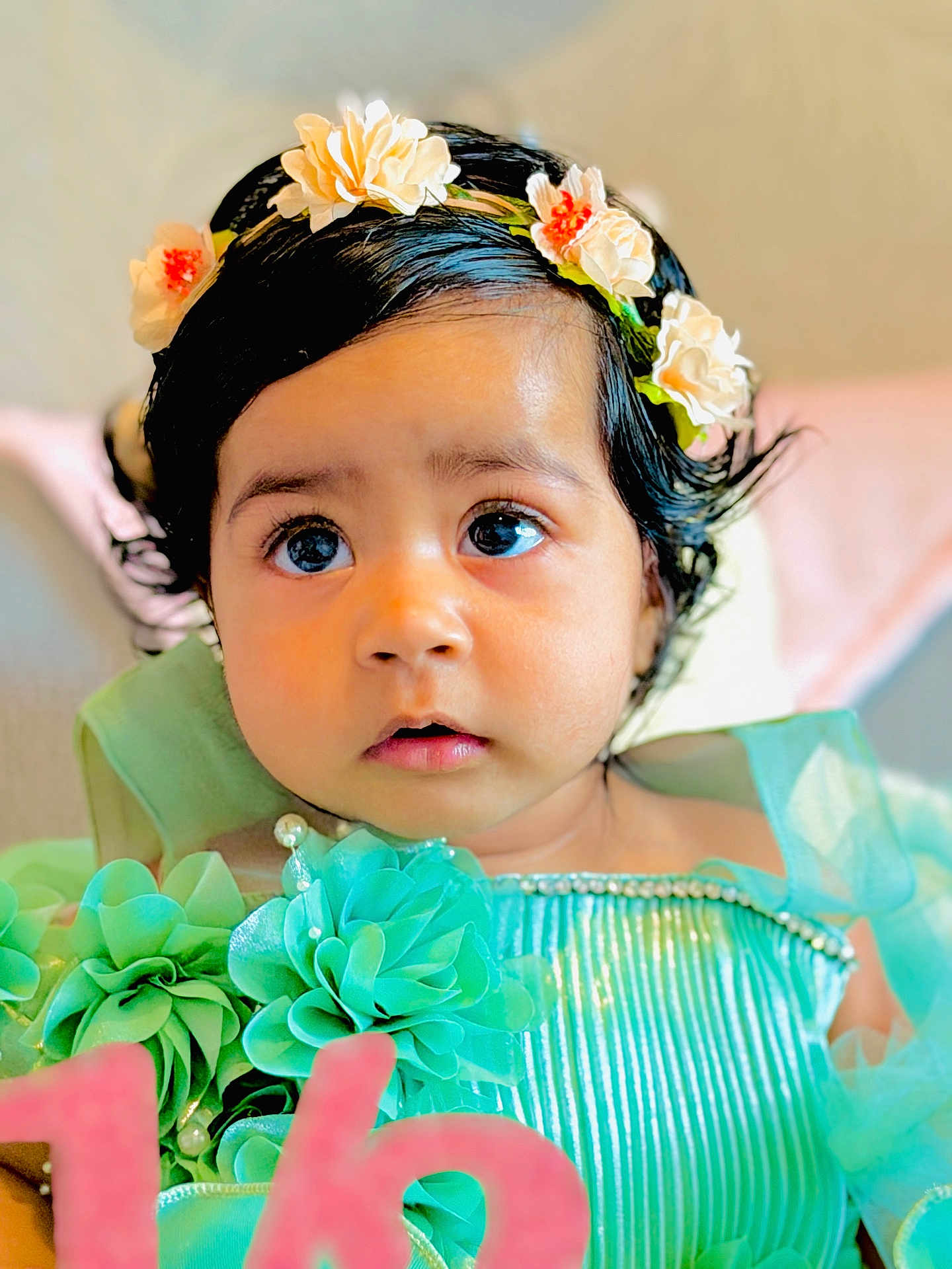 Jind is registered to the contest to win money with this photo: baby, child, female, flower_crown, blue_dress, fabric_flowers, pearls, portrait, close_up, curly_hair, big_eyes, soft_lighting, indoor, cute, adorable, young_child, celebration, decorative_clothing, head_accessory, looking_away