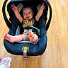 arms_up, baby, bib, bright, car_seat, child, clothing, cute, expression, foot, happy, indoors, infant, person, playful, safety, seatbelt, smile, wooden_floor, young_child