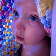 Jace is registered to the contest to win money with this photo: baby, child, face, blue_eyes, blanket, crocheted_blanket, colorful, close_up, skin, soft_light, portrait, expression, curious, indoors, newborn, infant, head, eyelashes, nostrils, cheeks
