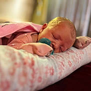 Mckenzie joined the competition — help win amazing prizes! baby, sleeping, pacifier, pink_clothing, blanket, cushion, infant, face, head, soft_fabric, indoors, resting, newborn, cozy, close_up, portrait, cute, peaceful, child, nursery