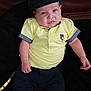 Raphaël a rejoint le concours — aidez-le/la à gagner de superbes lots ! baby, child, infant, cap, yellow_shirt, dark_pants, white_shoes, couch, leather, portrait, indoor, cute, fashion, seated, looking_at_camera, hands, feet, clothing, face, expression