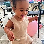 Chayna a rejoint le concours — aidez-le/la à gagner de superbes lots ! toddler, child, smiling, tongue_out, dress, sandals, indoor, floor, chair, ball, pigtails, playful, happy, person, cute, young_child, footwear, expression, fun, daylight