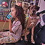 Zara is registered to the contest to win money with this photo: child, dog, indoor, gaming_device, couch, brindle_dog, pink_collar, long_hair, casual_clothing, action_figures, collectibles, sitting, playing, room, toys, entertainment, relaxed, pet, candid, home