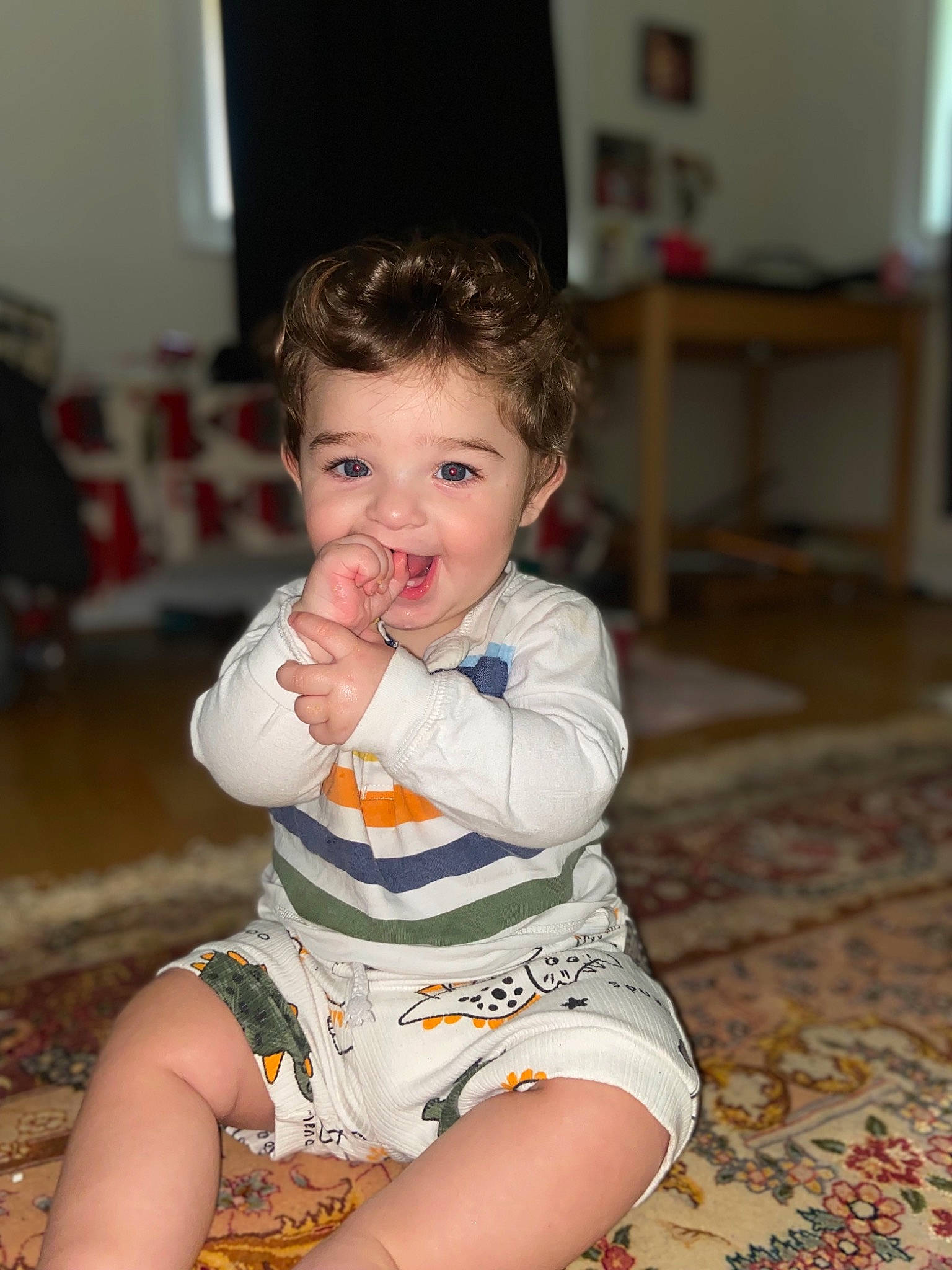 Eliam is registered to the contest to win money with this photo: baby, baby_toddler_clothing, cheek, child, dress, eye, face, facial_expression, finger, flooring, hairstyle, happy, head, iris, nose, person, sitting, skin, sleeve, smile