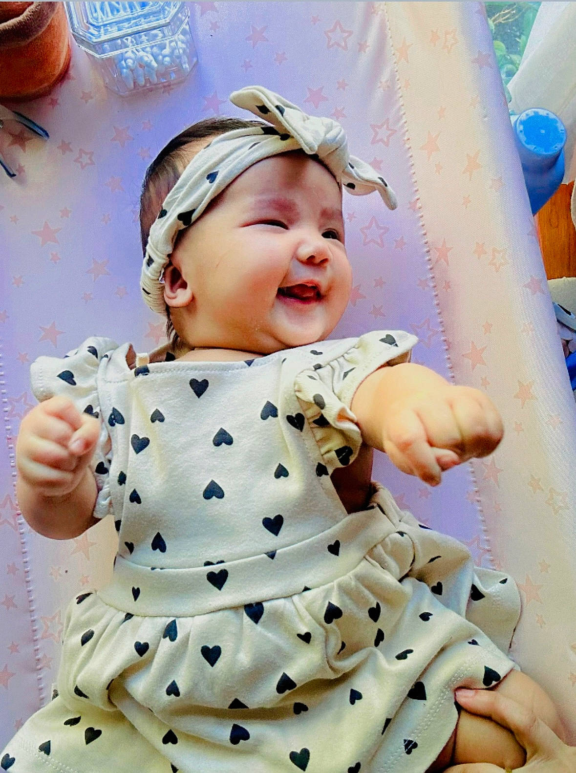 Luna Rose joined the competition — help win amazing prizes! baby, cheerful, child, cute, dress, dressed_up, happy, headband, heart_pattern, indoors, infant, pastel_background, patterned_clothing, person, portrait, reaching_out, small_hand, smiling, soft_lighting, star_pattern
