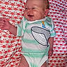 baby, baby_clothes, child, clothing, cute, fabric, green_stripes, happy, human, infant, joyful, lying_down, onesie, patterned_blanket, portrait, red, small_child, smiling, whale, white