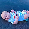 Hunter Gray is registered to the contest to win money with this photo: baby, blue, child, curious, cute, diaper, face, head, infant, lying_down, newborn, onesie, outdoor, pacifier, red_graphic, resting, skin, small_hands, texture, white_clothing
