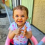baby, blue_eyes, child, concrete, door, hand, happy, outdoor, person, pink, playful, pointing, seatbelt, shirt, short_hair, smiling, stroller, sunlight, toddler, window