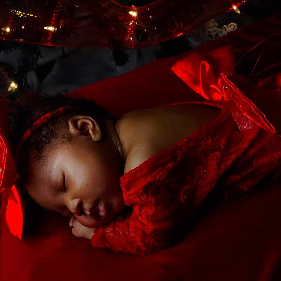 Nazuri joined the competition — help win amazing prizes! baby, bow, celebration, child, closeup, cozy, curly_hair, cute, decorations, festive, headband, holiday, indoors, infant, peaceful, portrait, red_dress, resting, sleeping, soft_lighting