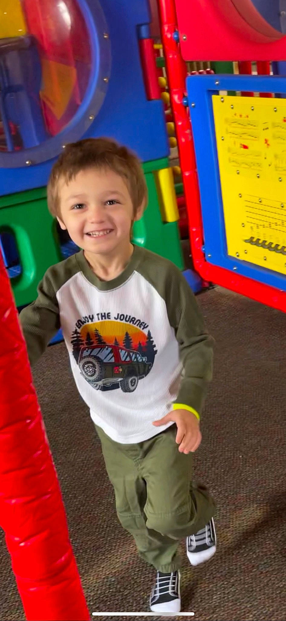 Marco is registered to the contest to win money with this photo: baby_toddler_clothing, blue, city, facial_expression, fun, happy, head, human, joy, leisure, orange, organ, outdoor_play_equipment, person, playground, recreation, red, sleeve, smile, standing