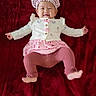 Nova joined the competition — help win amazing prizes! baby, infant, smile, pink_clothing, bonnet, blanket, lying_down, happy, cute, child, toddler, soft_texture, warm_colors, indoors, portrait, small_hands, small_feet, buttoned_jacket, patterned_clothing, cozy
