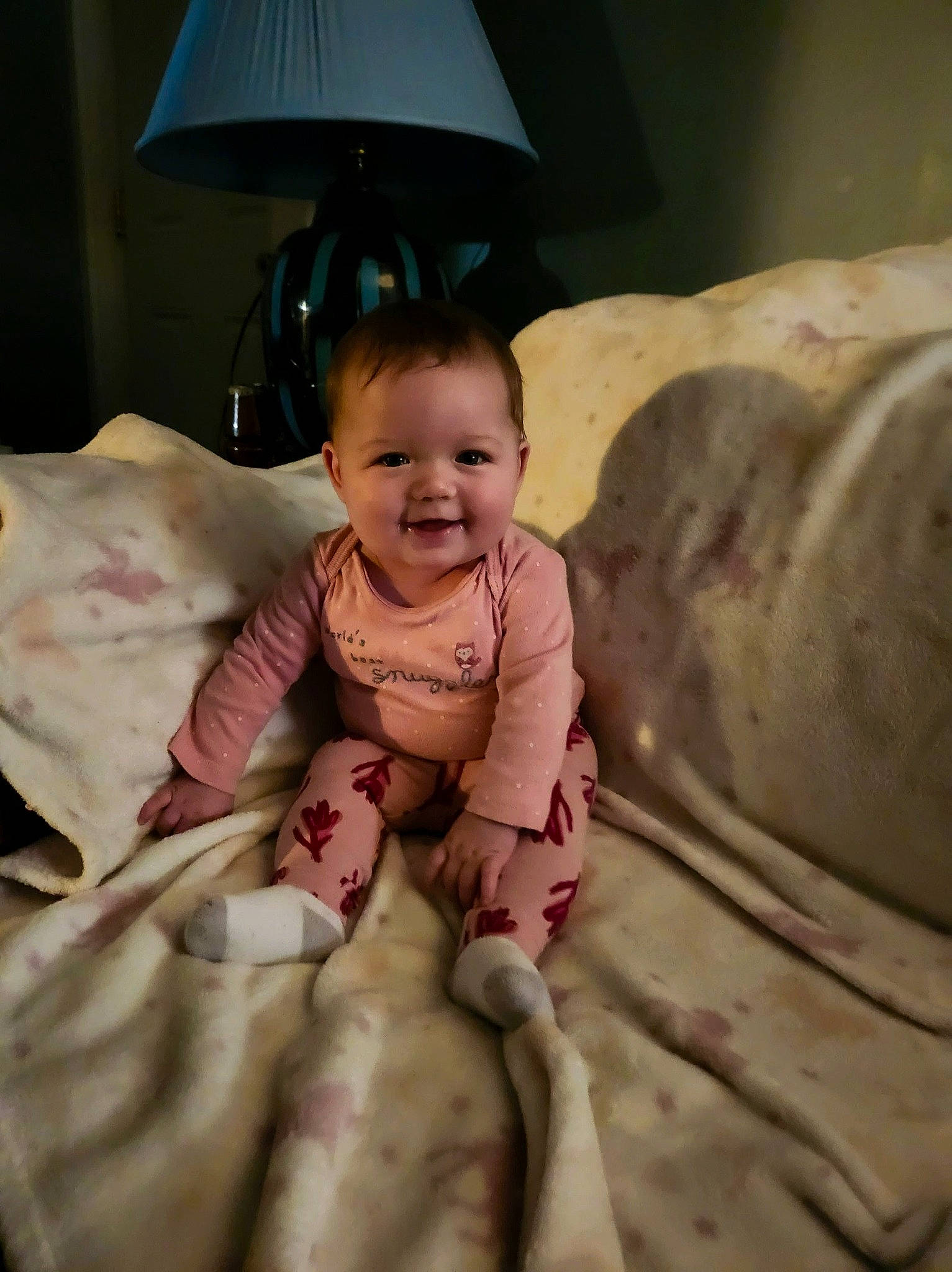 Jemma is registered to the contest to win money with this photo: baby, baby_toddler_clothing, bedding, cheek, child, comfort, eye, face, happy, head, human_body, joy, lamp, lampshade, linens, person, room, skin, sleeve, smile