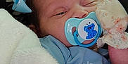 Octavia is registered to the contest to win money with this photo: baby, pacifier, blanket, mittens, bow, sleepy, closeup, face, infant, soft, floral, blue, cute, child, cozy, comfort, resting, indoors, person, newborn
