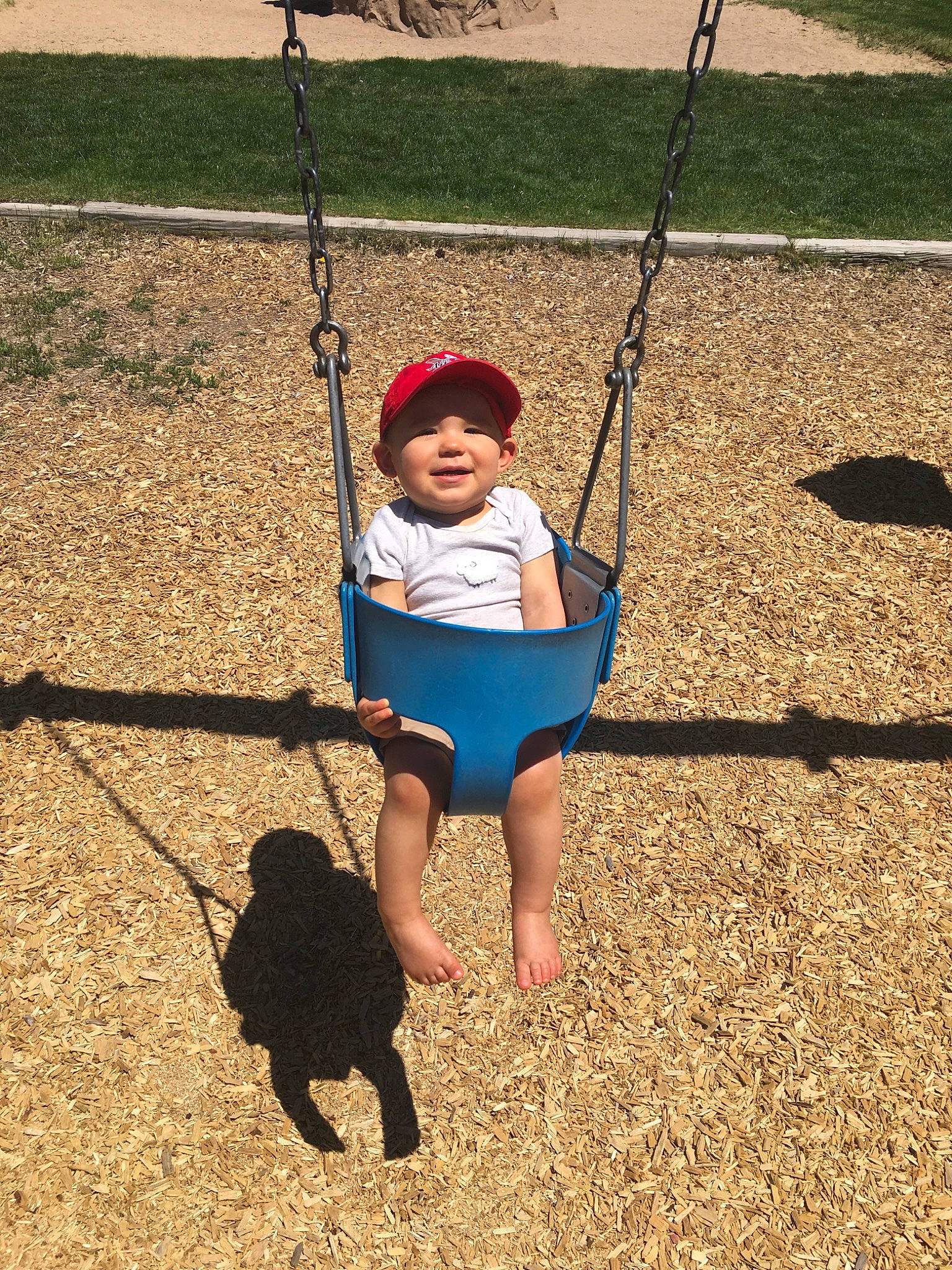 Silas is registered to the contest to win money with this photo: child, city, fun, grass, happy, human_settlement, joy, outdoor_play_equipment, person, plant, play, playground, public_space, recreation, smile, swing, toddler, tree, vacation