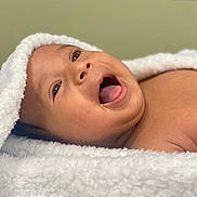 Jacob is registered to the contest to win money with this photo: baby, infant, smiling, happy, face, mouth_open, eyes, skin, towel, white, soft_texture, portrait, closeup, cute, newborn, child, expression, lying_down, warm, cozy