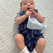 Bastidas is registered to the contest to win money with this photo: baby, infant, child, portrait, lying_down, bed, quilt, plush_toy, stuffed_bunny, sailor_outfit, navy_blue, striped_shirt, white_socks, hands, wide_eyes, open_mouth, indoor, cute, soft_lighting, photography