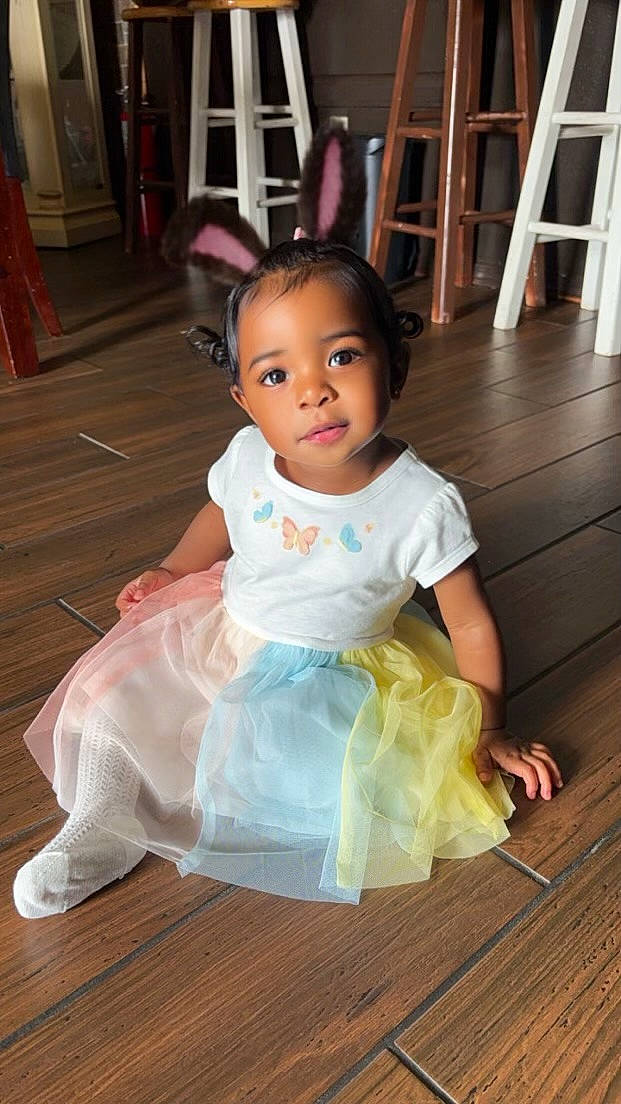 Keasia is registered to the contest to win money with this photo: baby, baby_toddler_clothing, chair, cheek, child, day_dress, event, flash_photography, floor, flooring, fun, happy, hardwood, iris, person, sitting, skin, toddler, wood, wood_flooring