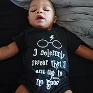 Stephen joined the competition — help win amazing prizes! arms, baby, bed, black_clothing, blanket, casual, clothing, cute, face, head, indoors, infant, legs, lying_down, onesie, person, portrait, soft_fabric, text, young_child
