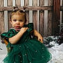background, candy_cane, child, cute, decoration, festive, girl, green_dress, holiday, indoor, lantern, pearls, pigtails, pine, portrait, rustic, seated, snow, winter, wooden_chair