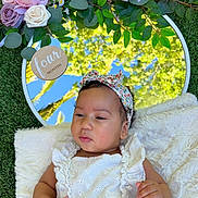 Reign is registered to the contest to win money with this photo: baby, infant, child, portrait, floral_headband, white_dress, smiling, serious_expression, lying_down, blanket, mirror, flowers, roses, greenery, grass, outdoor, garden, nature, reflection, baby_photoshoot