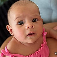 Jade is registered to the contest to win money with this photo: baby, infant, pink_clothing, face, eyes, skin, portrait, closeup, expression, child, person, cute, adorable, newborn, soft_light, indoor, human, young, head, shoulders