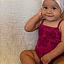 baby, girl, headband, bow, smile, sitting, couch, purple_outfit, floral_pattern, cute, child, indoors, skin, portrait, happy, one_person, infant, toddler, hand, face