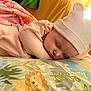 baby, sleeping, hat, blanket, pillow, animal_print, cute, child, indoors, cozy, soft, peaceful, rest, nap, bedtime, infant, face, headwear, comfort, warm