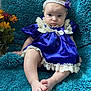 Defiance is registered to the contest to win money with this photo: baby, purple_dress, lace, headband, blue_blanket, flowers, infant, sitting, cute, portrait, soft_texture, child, foot, hand, indoor, cozy, fabric, person, young_child, decor