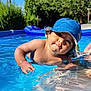 Théo participe au concours pour gagner de l'argent avec cette photo : baby, child, pool, water, blue_hat, sunny, outdoor, summer, trees, skin, droplets, curious, face, person, swimming, recreation, nature, daylight, blue_sky, relaxation