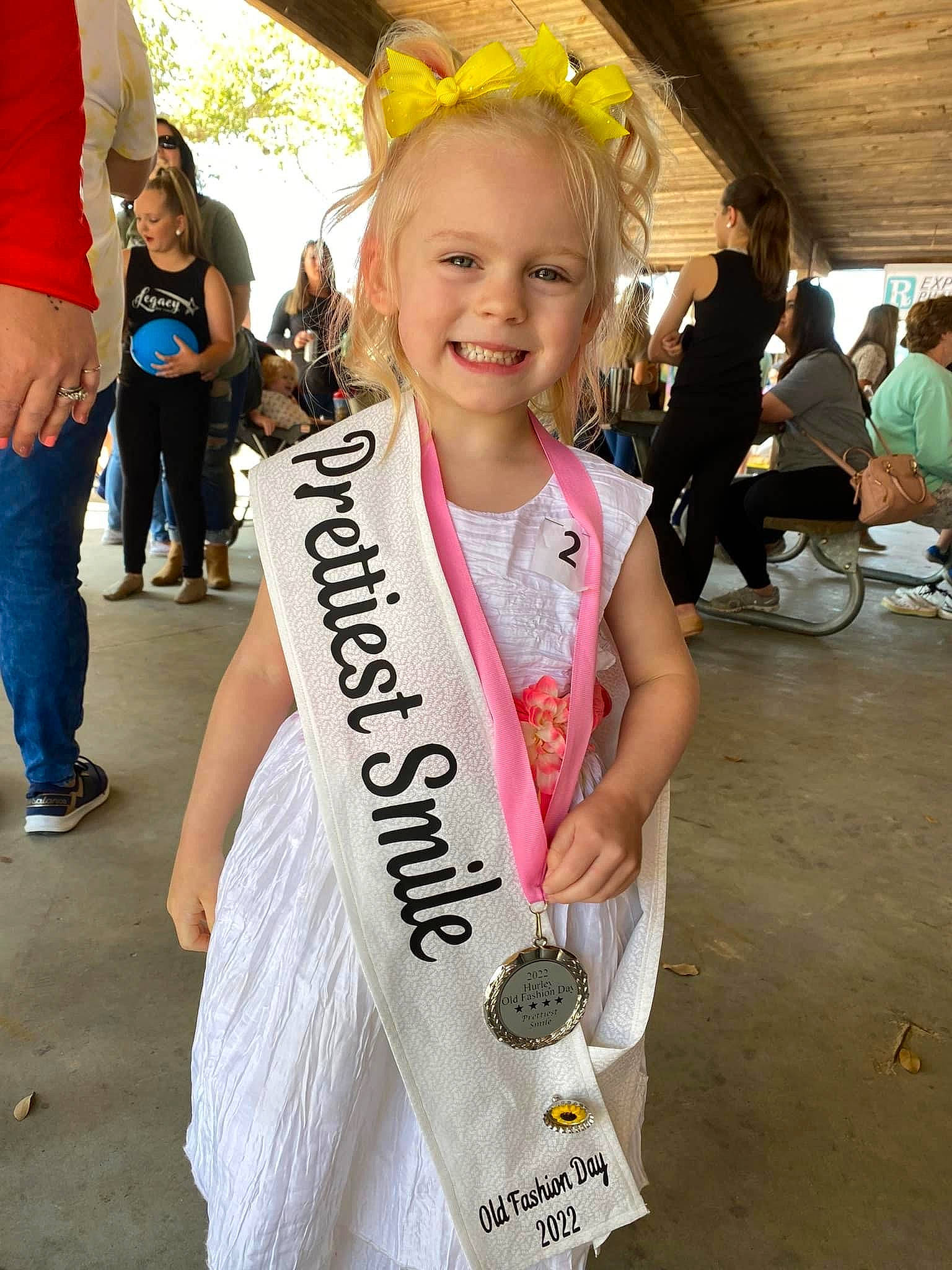 Arizona is registered to the contest to win money with this photo: blond, chair, child, clothing, event, facial_expression, fashion_accessory, fun, hairstyle, happy, jewellery, joy, person, recreation, shorts, smile, snapshot, street_fashion, t_shirt, toddler