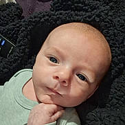Zayne is registered to the contest to win money with this photo: baby, infant, face, hand, clothing, blanket, expression, skin, person, newborn, cute, portrait, lying_down, looking, indoors, young_child, head, eyes, soft_texture, thoughtful