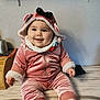 Alana a rejoint le concours — aidez-le/la à gagner de superbes lots ! adorable, baby, child, chubby_cheeks, cozy_clothing, cute, face, happy, hood, indoors, infant, marble_surface, person, pink_outfit, portrait, sitting, smiling, velour, wall, white_socks
