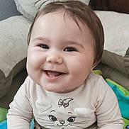 Alana participe au concours pour gagner de l'argent avec cette photo : baby, child, clothing, cushion, cute, drool, eyes, face, happy, head, indoor, infant, long_sleeve, person, playmat, portrait, sitting, smiling, soft, young_child