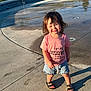 Penelope joined the competition — help win amazing prizes! toddler, child, outdoor, concrete, water_fountain, pink_shirt, denim_shorts, sandals, smile, sunlight, shadow, grass, curved_wall, summer, playground, casual_clothing, young_child, happy, person, daytime
