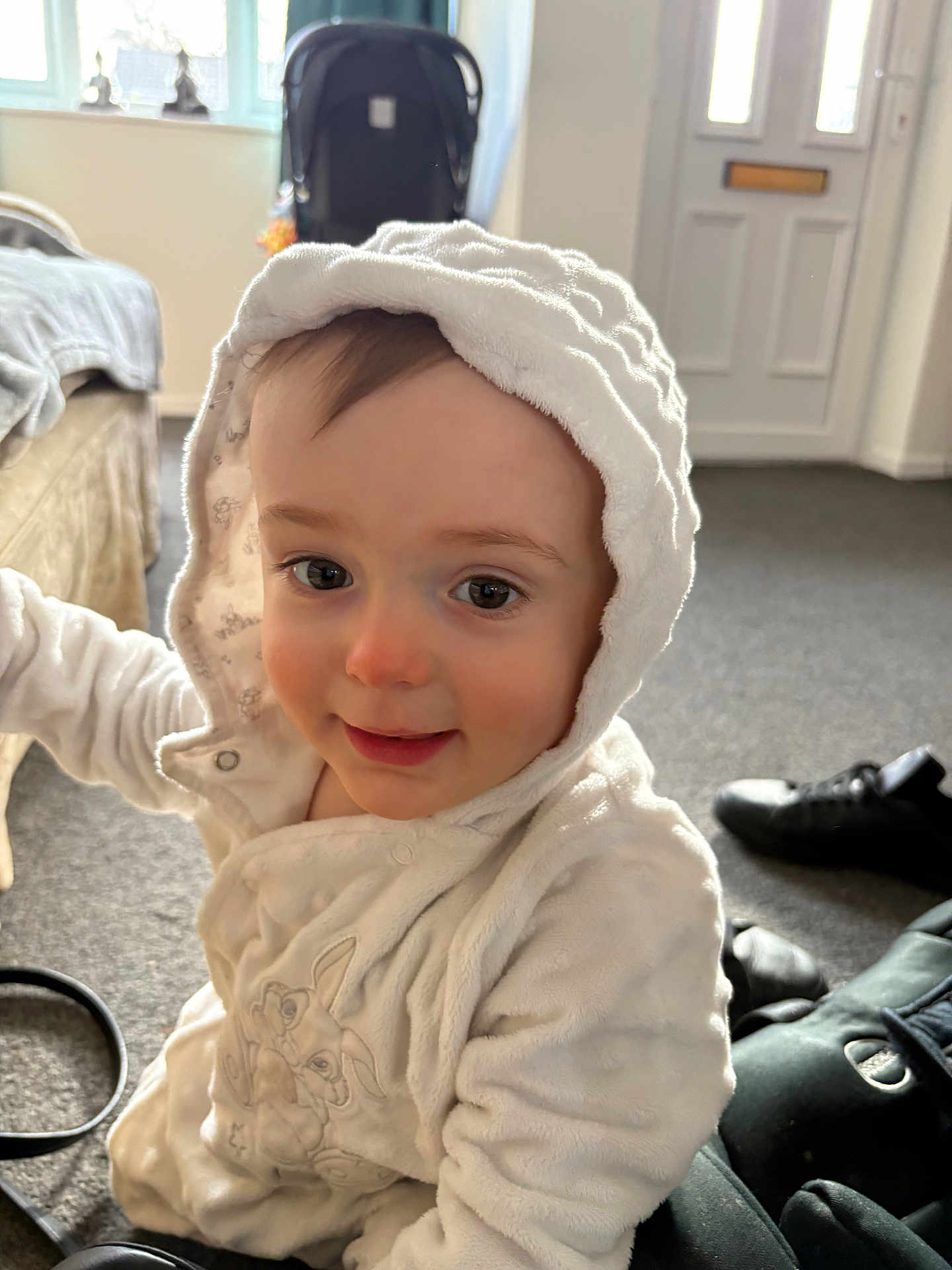 Arameus joined the competition — help win amazing prizes! toddler, child, hood, white_jacket, smile, indoor, carpet, shoes, stroller, face, curious, baby, warm_clothing, person, cute, young_child, portrait, cozy, home, expression