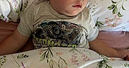 Kylan is registered to the contest to win money with this photo: toddler, sleeping, bed, pillow, blanket, floral_pattern, child, face, closed_eyes, shirt, monster_truck, comfort, indoors, rest, peaceful, cute, person, young_child, cozy, nap