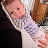 baby, child, infant, striped_shirt, person, indoor, furniture, curtains, wooden_cabinet, hand, blanket, holding, portrait, face, eyes, expression, cozy, resting, home, casual
